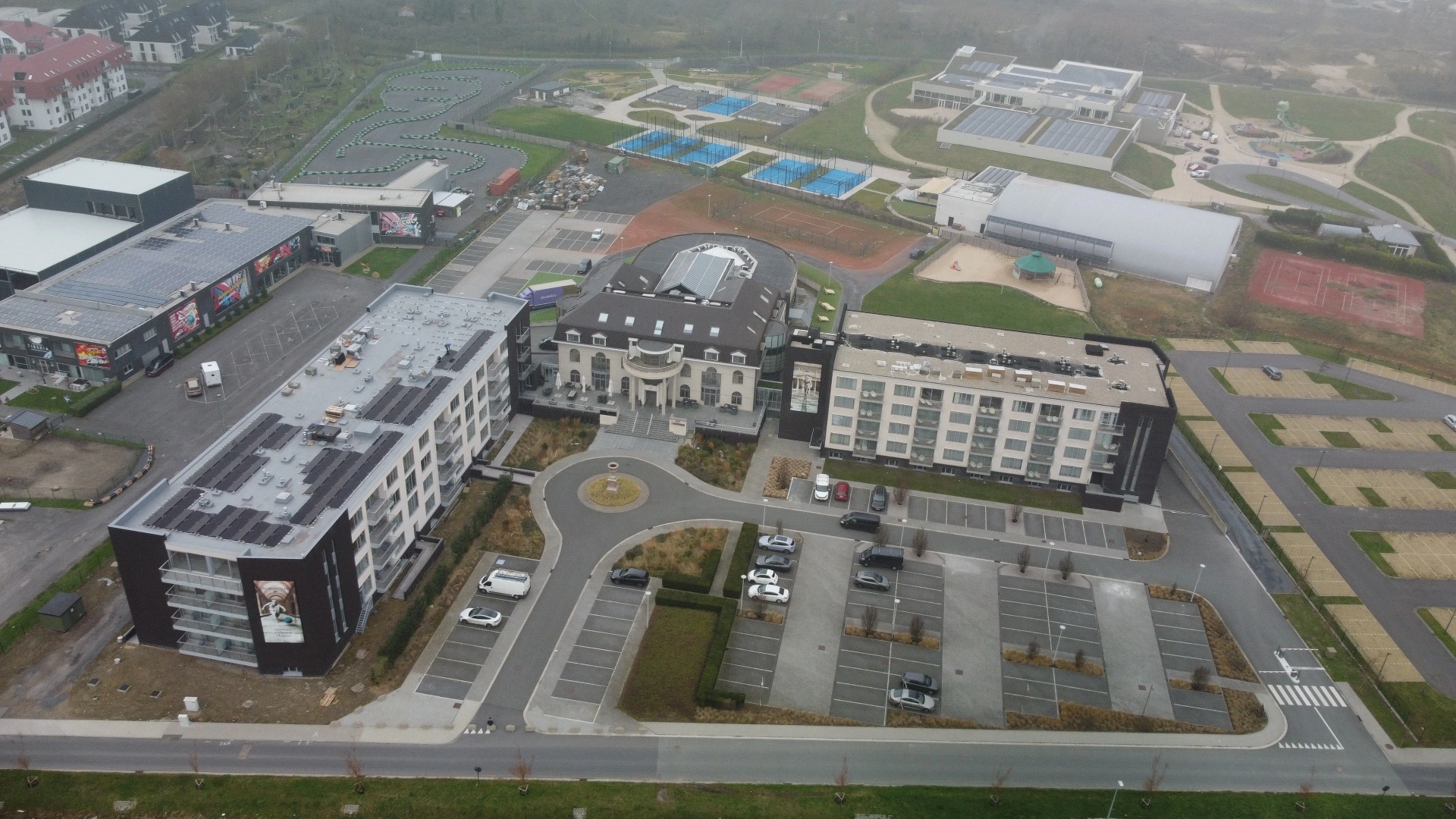 Solarnation referentie: 274,95 kWp zonne-installatie Hotel Acropolis Middelkerke met EV laadpalen Drone foto zonnepanelen Hotel Acropolis Middelkerke - 470 panelen oost-west opstelling op plat dak met laadinfrastructuur Solarnation